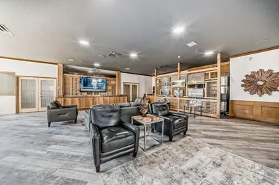 a living room with leather furniture and a flat screen tv at Invermere Inn & Suites in Invermere