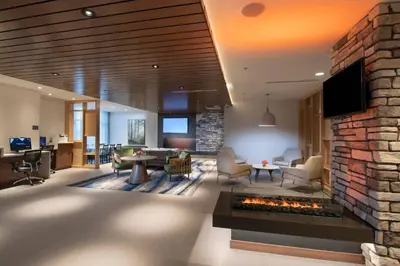 a living room with a fireplace and a tv at Fairfield by Marriott Edmonton International Airport in Edmonton