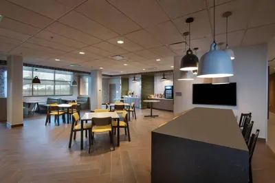 a restaurant with tables and chairs and a tv at Fairfield by Marriott Edmonton International Airport in Edmonton