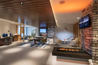 a lobby with a fireplace and a living room at Fairfield by Marriott Edmonton International Airport in Edmonton