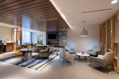 a lobby with chairs and tables and a living room at Fairfield by Marriott Edmonton International Airport in Edmonton