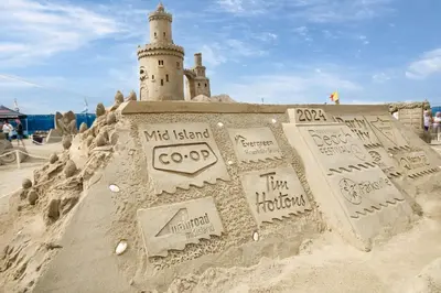 a sand castle with a lighthouse in the background at Coast Parksville Hotel in Parksville
