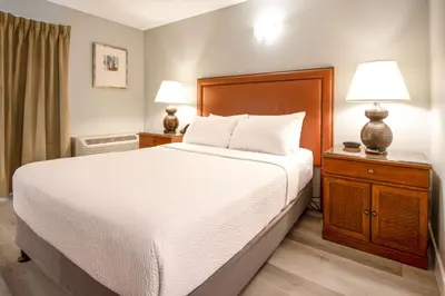a bedroom with a large bed and two lamps at Coast Parksville Hotel in Parksville