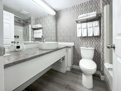 a white bathroom with a sink and a toilet at Coast Parksville Hotel in Parksville