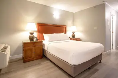 a bedroom with a bed and two lamps on night stands at Coast Parksville Hotel in Parksville