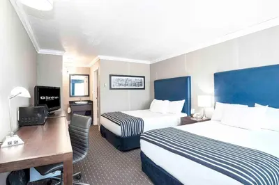 a hotel room with two beds and a desk at Sandman Inn Blue River in Blue River