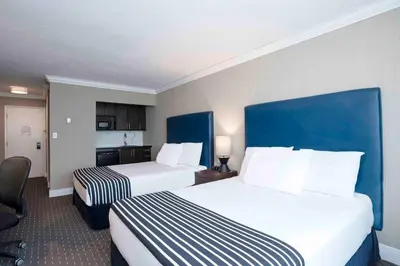a hotel room with two beds and a kitchen at Sandman Inn Blue River in Blue River