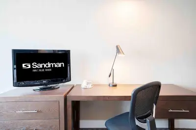a computer monitor sitting on top of a wooden desk at Sandman Inn Blue River in Blue River