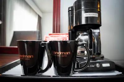 two coffee mugs on a tray next to a coffee maker at Sandman Inn Cache Creek in Cache Creek