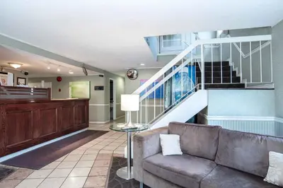 a living room with a couch and a staircase at Sandman Inn Cache Creek in Cache Creek
