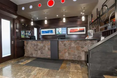a bar in a restaurant with a stone wall at Sandman Hotel Castlegar in Castlegar
