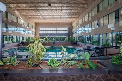 a large building with a pool and plants in it at Sandman Hotel Castlegar in Castlegar