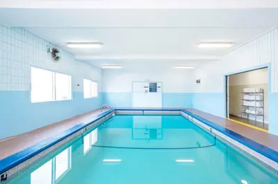a swimming pool in a gym with blue tiles at Sandman Hotel Cranbrook in Cranbrook