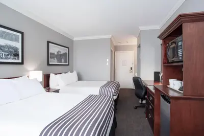 a hotel room with two beds and a desk at Sandman Inn Kamloops in Kamloops