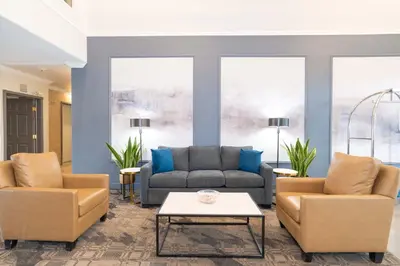 a living room with a couch and two chairs and a table at Sandman Hotel Quesnel in Quesnel