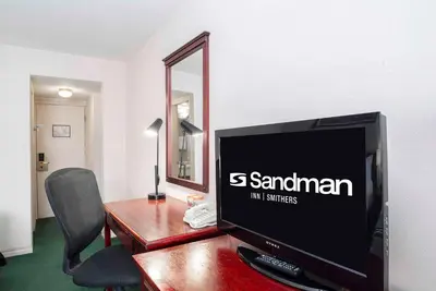 a computer monitor sitting on top of a wooden desk at Sandman Inn Smithers in Smithers