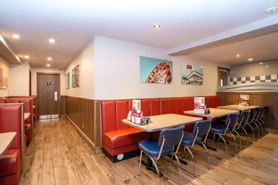 a restaurant with red booths and tables and chairs at Sandman Hotel Terrace in Terrace
