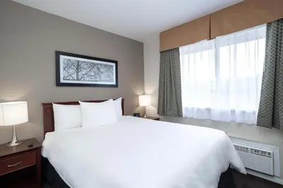 a bedroom with a large white bed and a window at Sandman Hotel & Suites Williams Lake in Williams Lake