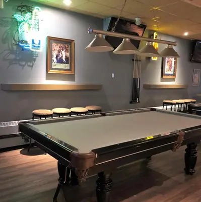 a pool table in a room with stools at Quality Hotel & Conference Centre in Peace River