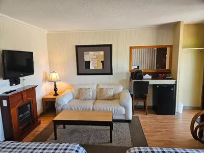a living room with a couch and a tv at Schooner Motel in Tofino