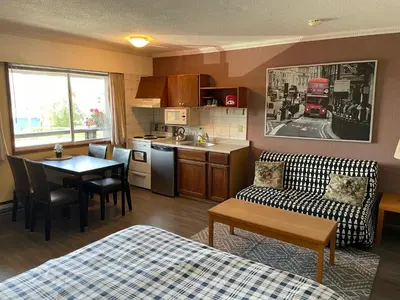 a room with a kitchen and a living room at Schooner Motel in Tofino