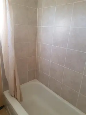 a bathroom with a bath tub with a shower curtain at Shamrock Motel in Valleyview