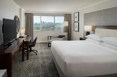 a hotel room with a large white bed and a desk at Sheraton Cavalier Calgary Hotel in Calgary