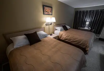 a hotel room with two beds and two lamps at Westwood Motel 100 Mile House in One Hundred Mile House