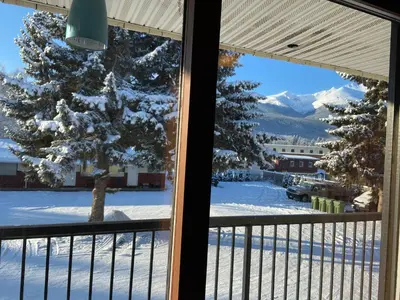 a view of a snow covered yard from a window at Mountain View Motel in Smithers