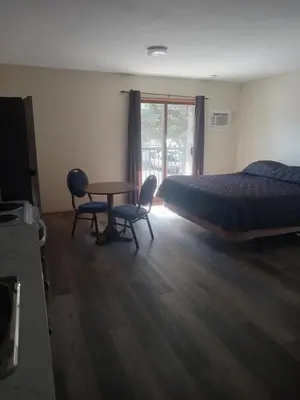a bedroom with a bed and a table and chairs at Mountain View Motel in Smithers