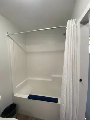 a bathroom with a shower curtain and a toilet at Mountain View Motel in Smithers