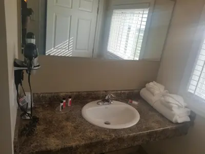 a bathroom counter with a sink and a mirror at Super 8 by Wyndham Smoky Lake in Smoky Lake