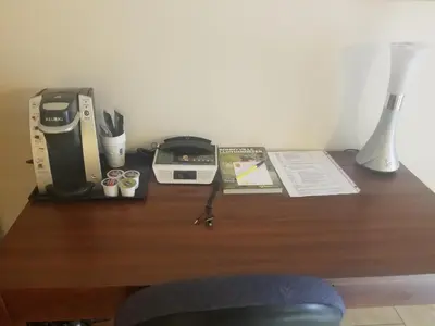 a desk with a coffee maker and a printer at Super 8 by Wyndham Smoky Lake in Smoky Lake