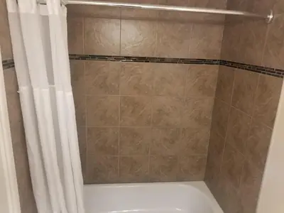 a shower with a white shower curtain and a tub at Super 8 by Wyndham Smoky Lake in Smoky Lake