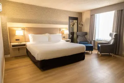a hotel room with a large bed and a chair at Radisson Hotel Fort St John in Fort Saint John
