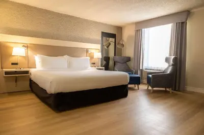 a hotel room with a bed and a chair at Radisson Hotel Fort St John in Fort Saint John