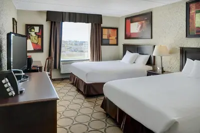 a hotel room with two beds and a desk at Radisson Hotel Fort St John in Fort Saint John