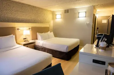 a hotel room with two beds and a desk at Radisson Hotel Fort St John in Fort Saint John