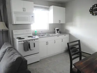 a kitchen with a stove and a sink and a microwave at Stratford Motel in Whitehorse