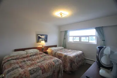 a hotel room with two beds and a window at Sunset Motel & Trailer Park, Incorporated in Port Alberni