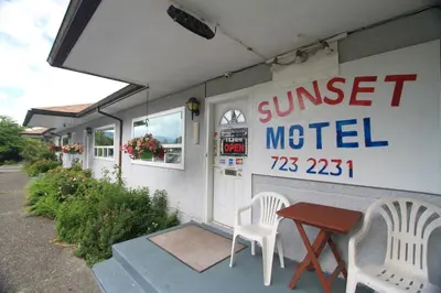 a sunset motel with two chairs and a table at Sunset Motel & Trailer Park, Incorporated in Port Alberni