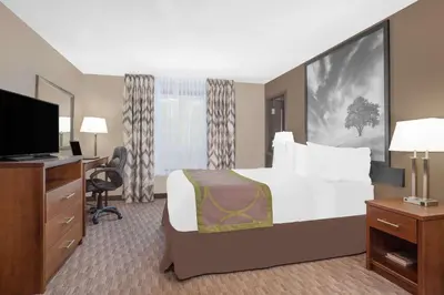a hotel room with a bed and a television at Super 8 by Wyndham Athabasca AB in Athabasca