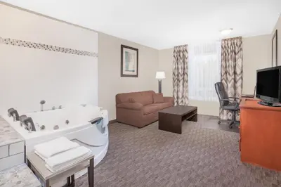 a living room with a bath tub and a couch at Super 8 by Wyndham Athabasca AB in Athabasca