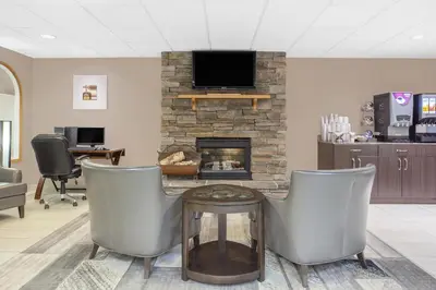 a living room with chairs and a fireplace at Super 8 by Wyndham Athabasca AB in Athabasca