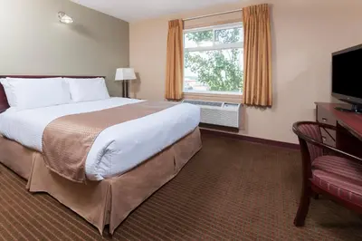 a hotel room with a large bed and a window at Super 8 by Wyndham Fort Saskatchewan in Fort Saskatchewan