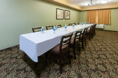 a conference room with a long table and chairs at Super 8 by Wyndham Fort Saskatchewan in Fort Saskatchewan