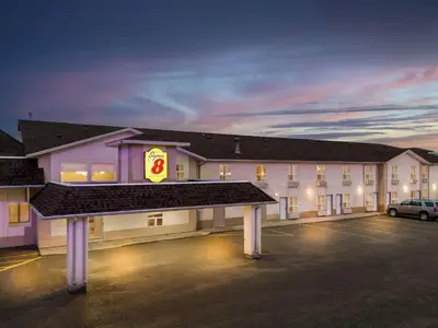 a large building with a parking lot in front of it at Super 8 by Wyndham Meadow Lake in Meadow Lake