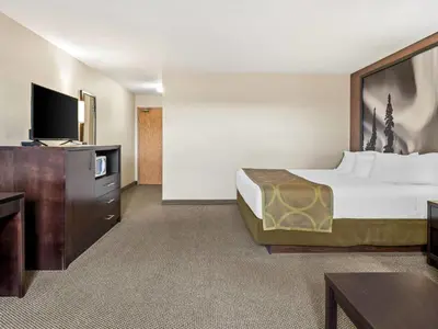a hotel room with a bed and a flat screen tv at Super 8 by Wyndham Meadow Lake in Meadow Lake