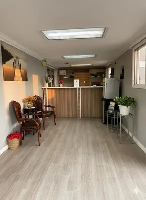 a living room with a table and chairs and a kitchen at Quesnel Inn in Quesnel