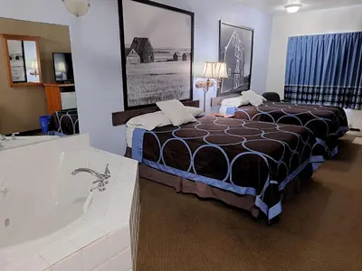 a hotel room with a bed and a bath tub at Super 8 by Wyndham Three Hills AB in Three Hills